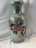 Front view of large sage green floor vase showing hand painted pink and purple peonies with leaves and birds outlined in gilt on marble-like glazed background.