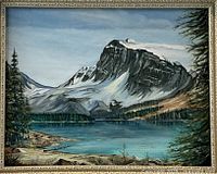 Full view of the framed oil painting depicting Bow Lake with mountains, pine trees, lake and rocks.