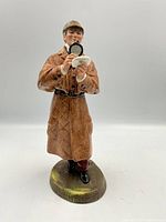 Front view of Royal Doulton Sherlock figurine holding pipe and magnifying glass.