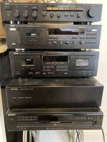 Front view of stacked components showing control amplifier, cassette decks, power amplifier, and CD player