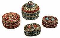 Four Tibetan lidded trinket boxes with red coral and turquoise inlay on white background