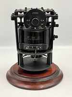 Front view of compass mechanism in metal gimbal mount on wood base