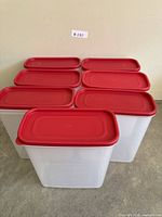 Seven identical clear plastic containers grouped, lids on