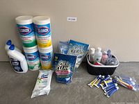 Full lot view with cleaning wipes, toilet bowl cleaners, detergent pouches, basket with medical items and ointment tubes