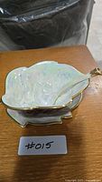 Sauce boat with ladle in bowl showing iridescent glaze and gold trim