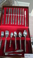 Open flatware box showing knives, forks, spoons