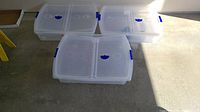 Three clear rolling underbed storage bins with blue latches