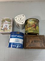 Top-down view of all five tins showing various vintage designs and shapes.