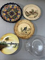 Five decorative plates on table showing diverse designs and materials
