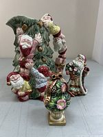 Photo showing the ceramic Christmas tree water jug with four Santa Claus figures climbing and hanging on the tree, decorated with gold ornaments