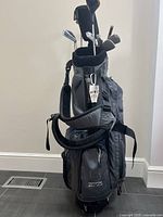 Full view of the Greystone branded golf bag in gray with two shoulder straps and multiple zippered pockets.