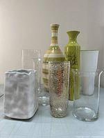 Group of seven decorative vases arranged on a surface.