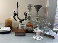 Overview of all candlesticks, battery candles, and stacks of coasters laid out on table
