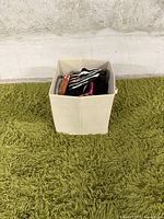 Photo of a beige fabric storage box containing the caps and headband.