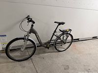 Grey step-through commuter e-bike with rear rack and battery