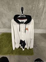 Front view of the white Nike Air XL hoodie with black hood, showing small logo on chest and full zipper