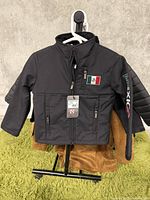 Front view of black kids jacket size M with zippers and Mexican flag patch on left chest