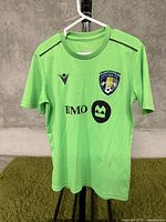 Front view of light green Vancouver Whitecaps kids sport shirt with sponsor logos.