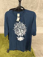 Full view of the blue T-shirt with the guitar tree graphic centered on the front.