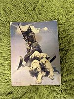 Fantasy art print showing a warrior armored figure on a sled pulled by four dogs in the snow.