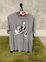 Front view of grey Nike Air T-shirt with logo graphic on chest