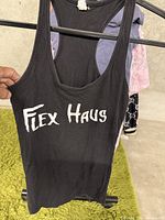 Front view of the black Flex Haus tank top showing the white printed 'Flex Haus' text.