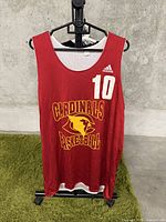 Front view of tank top showing red color, Adidas logo, Cardinals Basketball logo in yellow, and number 10 in white.