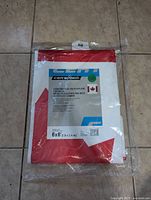 New Canadian flag polyethylene tarpaulin folded in packaging showing front label with size and product info.