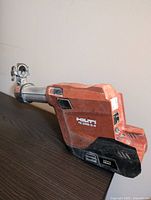 Side angle photo showing the main orange body and metal tube of the Hilti dust removal system with model number TE DRS-6-A visible.