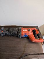 Side view of Hilti WSR 1000 reciprocating saw showing general condition and overall design with orange body and black handle.