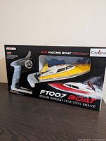 Box front showing FT007 yellow/white high speed racing boat and pistol grip remote control transmitter.
