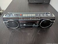 Front view of the Sanyo radio cassette recorder showing dual speakers, cassette player and controls.