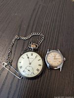 Front of Medana pocket watch with Roman numerals, showing chain and Omega wristwatch beside it.