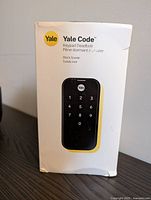 Front of product box showing Yale Code Keypad Deadbolt Black Suede lock with keypad image.