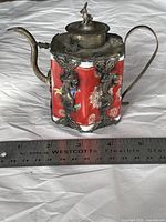 Photo of antique Chinese hexagonal teapot showing red and white porcelain panels with silver mounts, spout, lid, and handle. Measures approximately 4 inches.