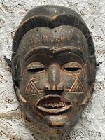 Front of the carved wooden African mask showing face and painted details.