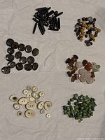Top view of six groups of assorted beads including black elongated, dark polished, carved light bone, green stone, decorative metal, and mixed stone beads.