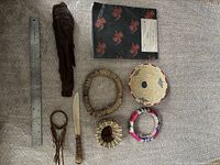 All 8 items of the lot arranged together showing varied First Nations style baskets, carved wooden artifacts, and bracelets alongside a small knife and ruler for scale.