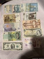 Photo showing ten international paper currency bills from Sweden, Australia, South Africa, Canada, USA, and Mexico.