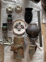 Full view of all 11 items arranged together including pottery, glass vases, onyx mask, and decorative pieces with ruler for scale