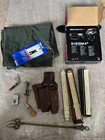 Full lot showing rain pants, bike light in box, leather cutter sheath, slide rules and additional tools