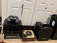 Stacked view of all nine electronics including radio cassette player, CD players, cassette decks, turntable and subwoofer