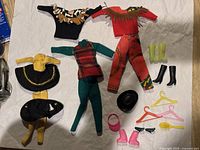 All 22 vintage Barbie clothing pieces and accessories arranged and laid out.