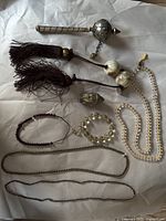 Overview of all nine vintage Buddhist items including prayer beads, a prayer wheel, and a Buddha figurine on white paper.