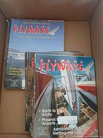 Top view of a stack of Arizona Flyways magazines showing multiple issues with colorful aviation-themed covers.
