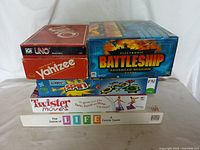 Stacked boxes of six board games showing front and top faces.