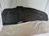 Full view of black FIELOLINE tactical rifle case showing multiple front pockets and carrying handles.