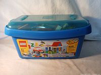 Blue LEGO container with original label showing a LEGO house set image on the side