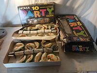 Photo of two open boxes containing 10 fish-shaped Noma Party Lights each, with their respective boxes showing wear.