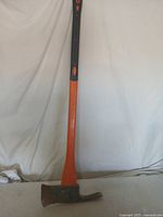 Full view of the 36 inch orange axe showing the head with blade and pick sides and the black grip handle.